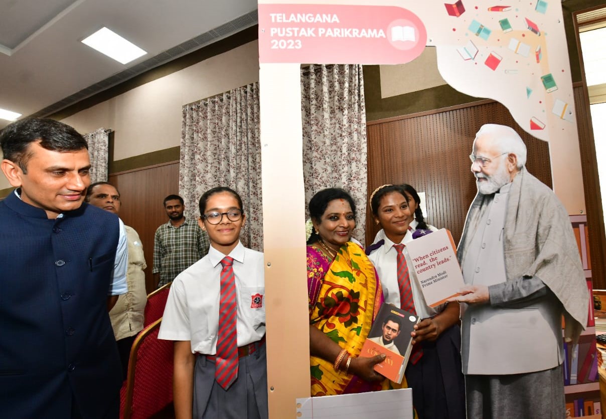 Governor Dr Tamilisai Soundararajan presents 'Exam Warriors' book penned by Prime Minister Narendra Modi, to all the students participated in the meeting.